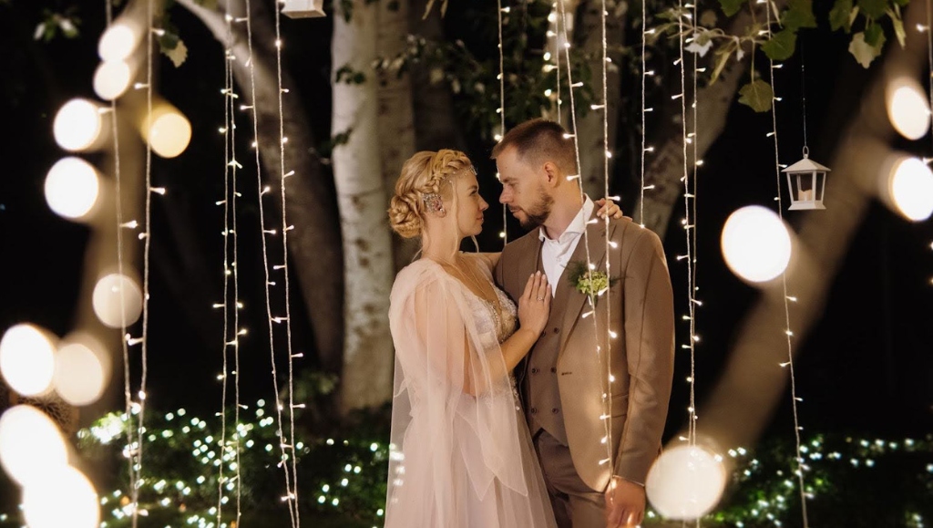 Image of a lovely couple amongst twinkling lights at a night wedding
